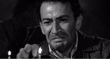 Movie still from “Night of the Eagle” (1962), directed by Sidney Hayers – Black and white photograph of a man looking sad; Close Up shot, Low angle