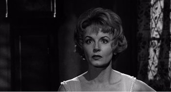 Movie still from “Night of the Eagle” (1962), directed by Sidney Hayers – An old photo of an older woman looking at the camera; Close Up shot, Low angle