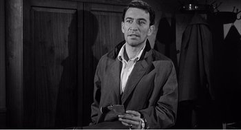 Movie still from “Night of the Eagle” (1962), directed by Sidney Hayers – A black and white photo of a man in a suit; Medium shot, Low angle