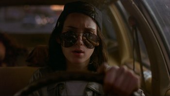 Movie still from “Night on Earth” (1991), directed by Jim Jarmusch – A woman driving a car wearing sunglasses and holding a steering wheel; Close Up shot, Low angle