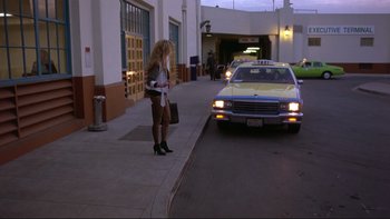 Movie still from “Night on Earth” (1991), directed by Jim Jarmusch – A woman standing next to a car on the side of the street; Wide shot, Low angle
