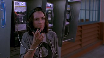 Movie still from “Night on Earth” (1991), directed by Jim Jarmusch – A woman talking on a phone while wearing headphones; Close Up shot, High angle