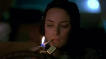 Movie still from “Night on Earth” (1991), directed by Jim Jarmusch – A woman lighting a cigarette with a lighter; Close Up shot, High angle