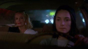 Movie still from “Night on Earth” (1991), directed by Jim Jarmusch – Two women sitting in the back seat of a car at night; Close Up shot, Over the shoulder angle