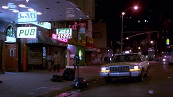 Movie still from “Night on Earth” (1991), directed by Jim Jarmusch – A taxi cab is parked on the side of the street; Wide shot, High angle