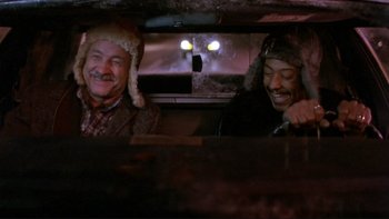 Movie still from “Night on Earth” (1991), directed by Jim Jarmusch – Two men sitting in the back seat of a car; Medium shot, High angle