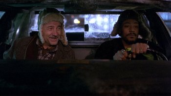 Movie still from “Night on Earth” (1991), directed by Jim Jarmusch – Two men sitting in the back of a car; Medium shot, Over the shoulder angle