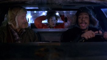 Movie still from “Night on Earth” (1991), directed by Jim Jarmusch – Two men sitting at a table in front of a television; Medium shot, Over the shoulder angle