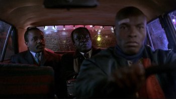 Movie still from “Night on Earth” (1991), directed by Jim Jarmusch – A group of men sitting in the back of a bus; Close Up shot, Low angle
