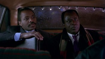 Movie still from “Night on Earth” (1991), directed by Jim Jarmusch – A couple of men sitting next to each other on top of a bus; Close Up shot, Low angle