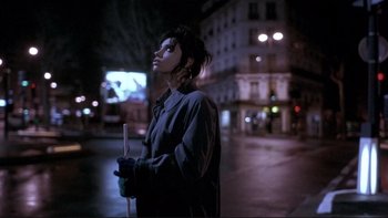 Movie still from “Night on Earth” (1991), directed by Jim Jarmusch – A woman standing in the dark holding a white stick; Medium shot, Low angle