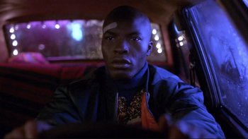 Movie still from “Night on Earth” (1991), directed by Jim Jarmusch – A man with a bandage on his head sitting in the back of a car; Close Up shot, Low angle