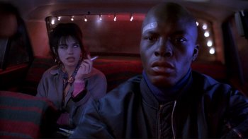 Movie still from “Night on Earth” (1991), directed by Jim Jarmusch – A man and a woman sitting in a car smoking; Close Up shot, Low angle