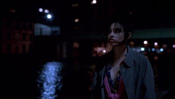 Movie still from “Night on Earth” (1991), directed by Jim Jarmusch – A woman standing in the dark near a body of water at night; Close Up shot, High angle