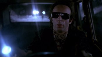 Movie still from “Night on Earth” (1991), directed by Jim Jarmusch – A man sitting in the driver's seat of a car at night; Close Up shot, Low angle