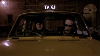 Movie still from “Night on Earth” (1991), directed by Jim Jarmusch – Two men in a yellow taxi cab at night; Medium shot, Low angle