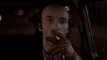 Movie still from “Night on Earth” (1991), directed by Jim Jarmusch – A man smoking a cigarette while wearing a suit and tie; Close Up shot, Low angle