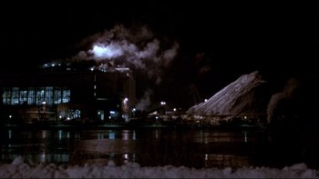 Movie still from “Night on Earth” (1991), directed by Jim Jarmusch – A factory with smoke billowing out of the top of the building; Extreme Wide shot, High angle