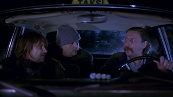Movie still from “Night on Earth” (1991), directed by Jim Jarmusch – A group of men sitting in the back of a car; Medium shot, High angle