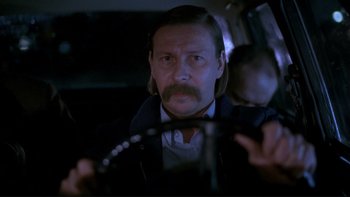 Movie still from “Night on Earth” (1991), directed by Jim Jarmusch – A man with a mustache is sitting in a car; Close Up shot, Low angle