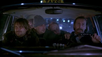 Movie still from “Night on Earth” (1991), directed by Jim Jarmusch – A group of people sitting in the back of a car; Medium shot, Low angle