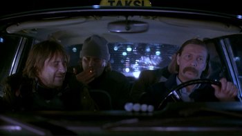 Movie still from “Night on Earth” (1991), directed by Jim Jarmusch – A group of people sitting in the back of a car; Medium shot, Low angle
