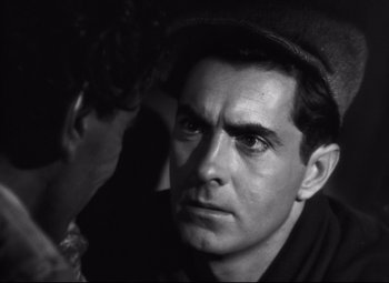 Movie still from “Nightmare Alley” (1947), directed by Edmund Goulding – Black and white photograph of a man with a hat; Close Up shot, Over the shoulder angle