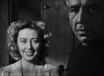 Movie still from “Nightmare Alley” (1947), directed by Edmund Goulding – An older man and a younger woman posing for a picture; Close Up shot, Low angle