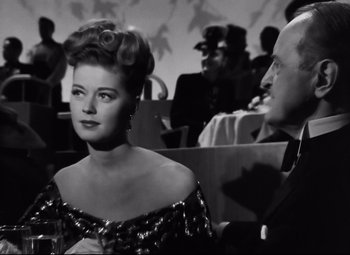 Movie still from “Nightmare Alley” (1947), directed by Edmund Goulding – An old photo of a man and a woman; Medium shot, Over the shoulder angle