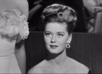 Movie still from “Nightmare Alley” (1947), directed by Edmund Goulding – A black and white photo of a woman in a dress; Close Up shot, Low angle