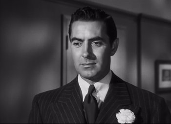 Movie still from “Nightmare Alley” (1947), directed by Edmund Goulding – Black and white photograph of a man wearing a suit and tie; Close Up shot, Low angle