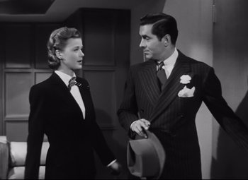 Movie still from “Nightmare Alley” (1947), directed by Edmund Goulding – A man and a woman standing next to each other; Medium shot, Low angle