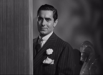 Movie still from “Nightmare Alley” (1947), directed by Edmund Goulding – Black and white photograph of a man wearing a suit and tie; Close Up shot, Low angle