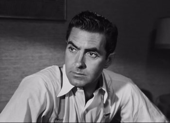 Movie still from “Nightmare Alley” (1947), directed by Edmund Goulding – Black and white photograph of a man in a dress shirt and suspenders; Close Up shot, Low angle