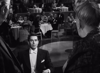 Movie still from “Nightmare Alley” (1947), directed by Edmund Goulding – A black and white photo of a man and a woman in front of an audience; Medium shot, Over the shoulder angle