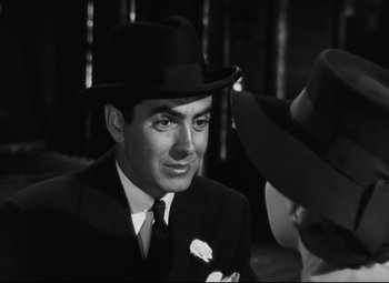 Movie still from “Nightmare Alley” (1947), directed by Edmund Goulding – A man in a suit and a black hat; Close Up shot, Over the shoulder angle