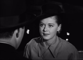 Movie still from “Nightmare Alley” (1947), directed by Edmund Goulding – A black and white photo of a woman wearing a hat; Close Up shot, Over the shoulder angle