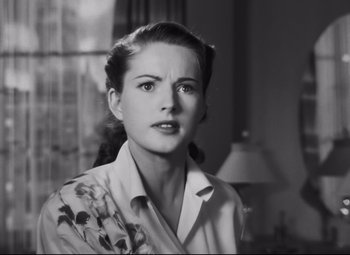 Movie still from “Nightmare Alley” (1947), directed by Edmund Goulding – A black - and - white photo of a woman in a white shirt; Close Up shot, Low angle