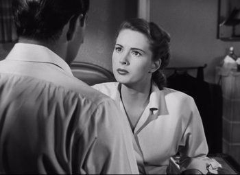 Movie still from “Nightmare Alley” (1947), directed by Edmund Goulding – A woman is talking to a man in front of a mirror; Close Up shot, Over the shoulder angle