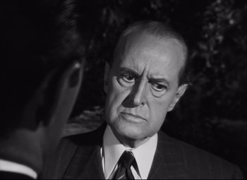 Movie still from “Nightmare Alley” (1947), directed by Edmund Goulding – An older man wearing a suit and tie; Close Up shot, Over the shoulder angle