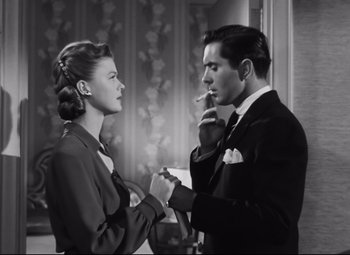 Movie still from “Nightmare Alley” (1947), directed by Edmund Goulding – A man and a woman standing next to each other; Medium shot, Low angle