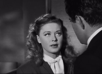 Movie still from “Nightmare Alley” (1947), directed by Edmund Goulding – A woman in a suit and a man in a tie; Close Up shot, Over the shoulder angle