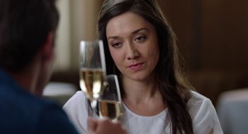 Movie still from “Nightmare Cinema” (2018), directed by Alejandro Brugués – A woman holding a glass of wine in front of her face; Close Up shot, Over the shoulder angle