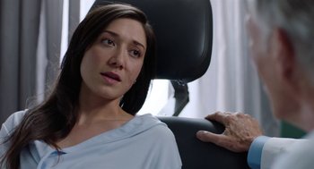 Movie still from “Nightmare Cinema” (2018), directed by Alejandro Brugués – A woman sitting in a chair with her hand on the back of her head; Close Up shot, Over the shoulder angle