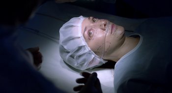 Movie still from “Nightmare Cinema” (2018), directed by Alejandro Brugués – A person with a head covered in a surgical cap; Close Up shot, Overhead angle