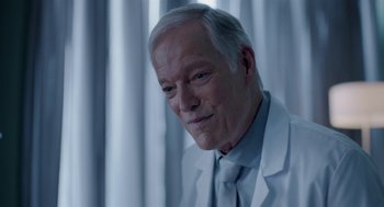 Movie still from “Nightmare Cinema” (2018), directed by Alejandro Brugués – An older man wearing a white lab coat; Close Up shot, Over the shoulder angle