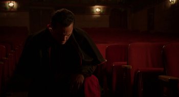 Movie still from “Nightmare Cinema” (2018), directed by Alejandro Brugués – A man sitting on a chair in a theater; Medium shot, Low angle