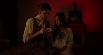 Movie still from “Nightmare Cinema” (2018), directed by Alejandro Brugués – Two women in a room with a cross on the wall; Medium shot, Over the shoulder angle