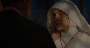 Movie still from “Nightmare Cinema” (2018), directed by Alejandro Brugués – A woman wearing a nun's outfit looking into a mirror; Close Up shot, Over the shoulder angle