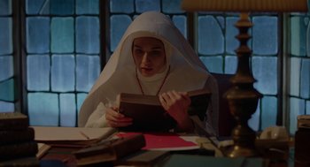 Movie still from “Nightmare Cinema” (2018), directed by Alejandro Brugués – A woman in a nun's outfit is reading a book; Medium shot, High angle